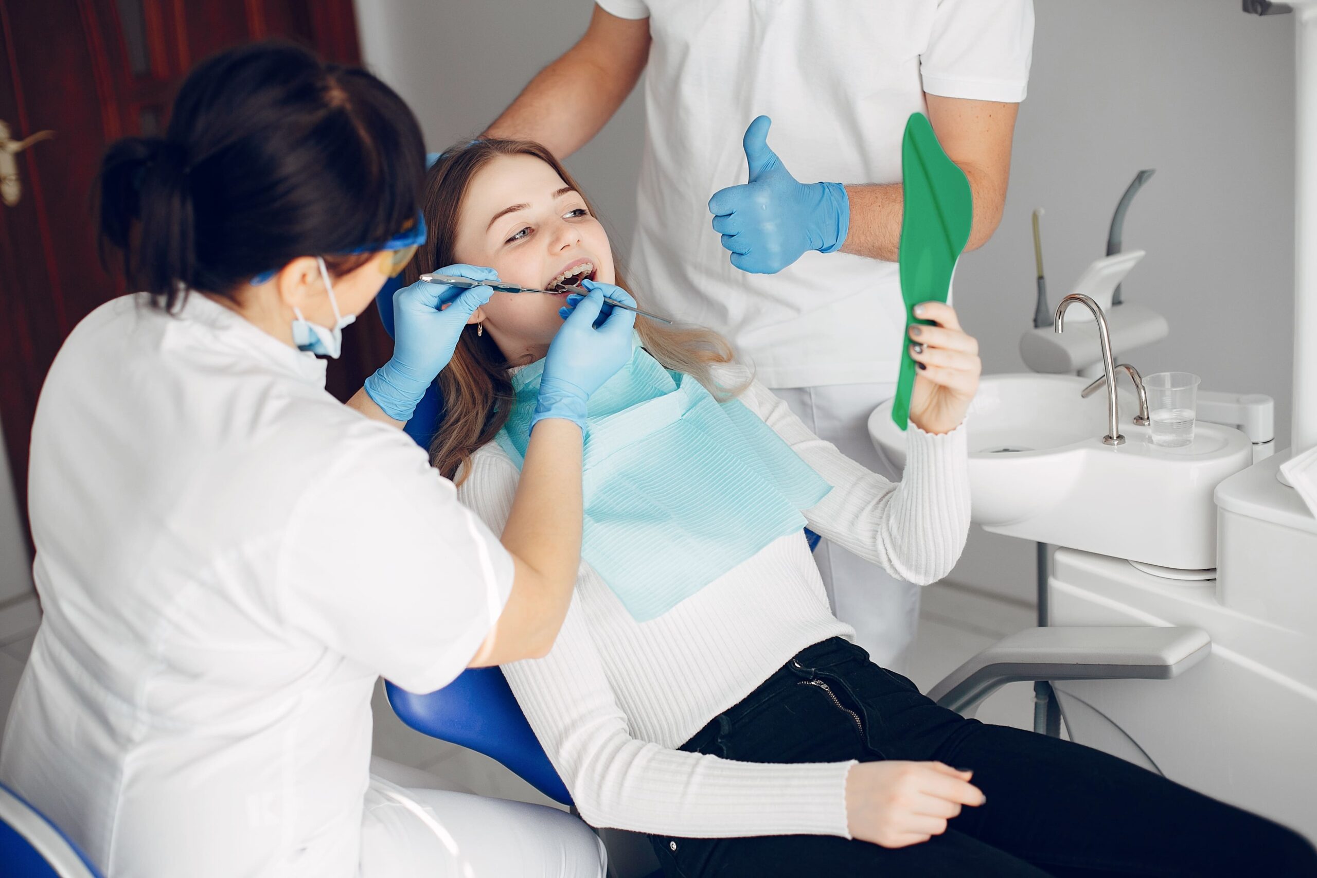 beautiful-girl-sitting-dentist-s-office Female patient receiving a dental checkup